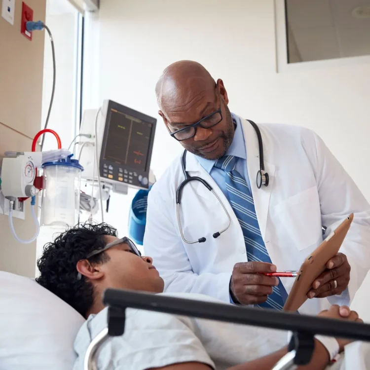 doctor explaining chart items to a patient in a hospital bed
