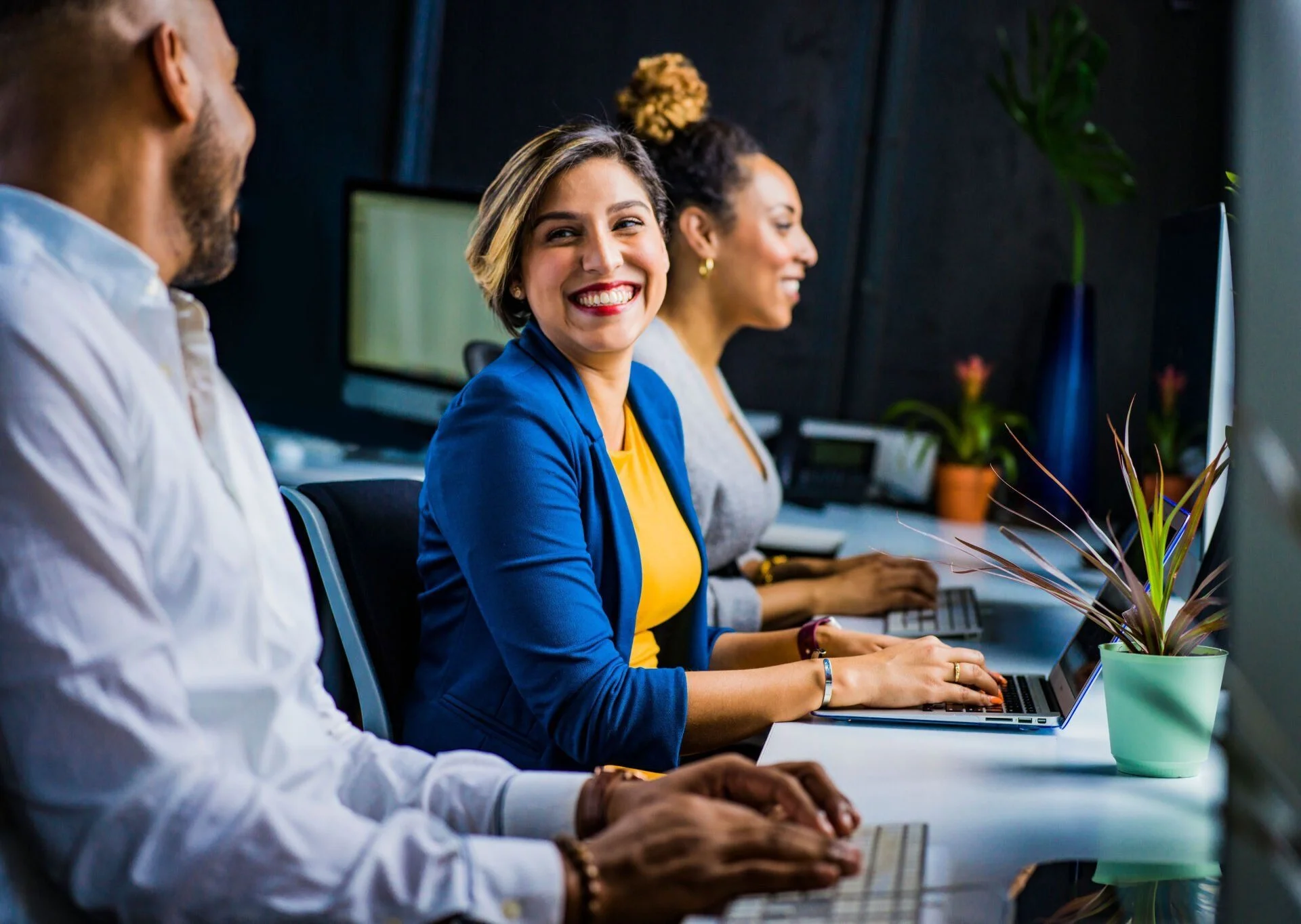people in a meeting, woman smiling happily at the table