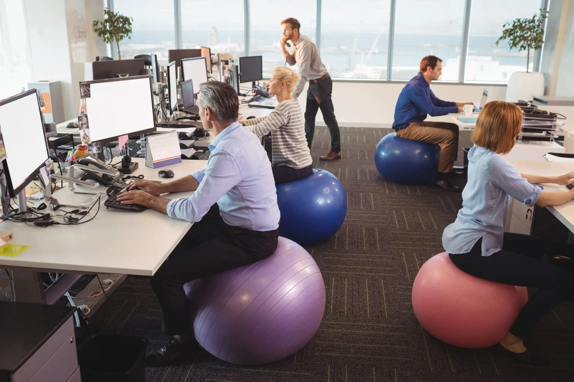 office staff at their desks sitting on yoga balls